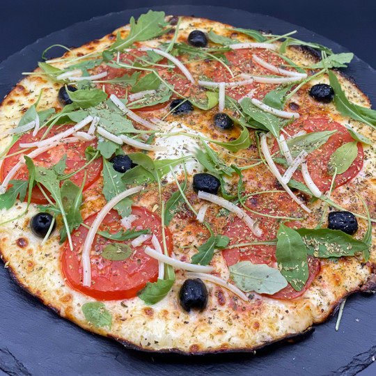MARGHERITA DU CHEF : Sauce tomate maison, mozzarella 100 %, rondelles de tomate, olives, roquette, Comté AOC, origan.