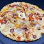 MERGUEZ COMTE :Sauce tomate maison, mozzarella 100 %, merguez, oignons, origan (halal).