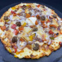 NEWYORK : Crème fraîche, mozzarella 100 %, steak haché, boulettes, comté, poivrons grillés, oignons, sauce barbecue (halal).