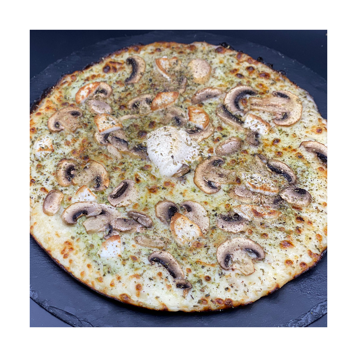 PESTO MERVEILLEUSE : Crème fraîche, mozzarella 100 %, champignons, chèvre, pesto, origan.