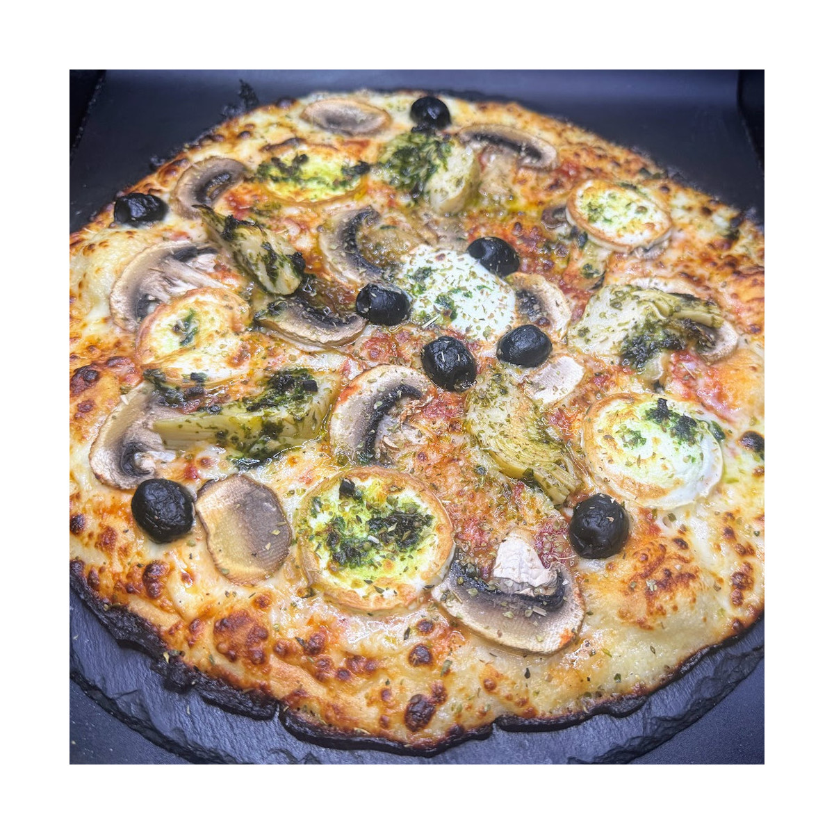 BERGERE : Sauce tomate maison, mozzarella 100 %, artichauts à la romaine, champignons, chèvre, olives, origan.