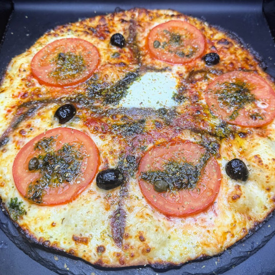 NAPOLITAINE : Sauce tomate maison, mozzarella 100 %, rondelles de tomate, anchois, câpres, olives, origan.