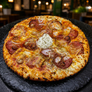 CALIENTE : Sauce tomate maison, mozzarella 100 %, merguez, chorizo, oignons, comté, origan.