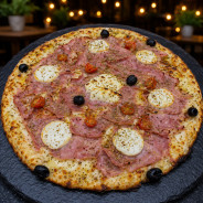 JAMBON CHEVRE : Sauce tomate maison, mozzarella 100 %, jambon blanc, chèvre, tomates cerises, olives, origan, ail.